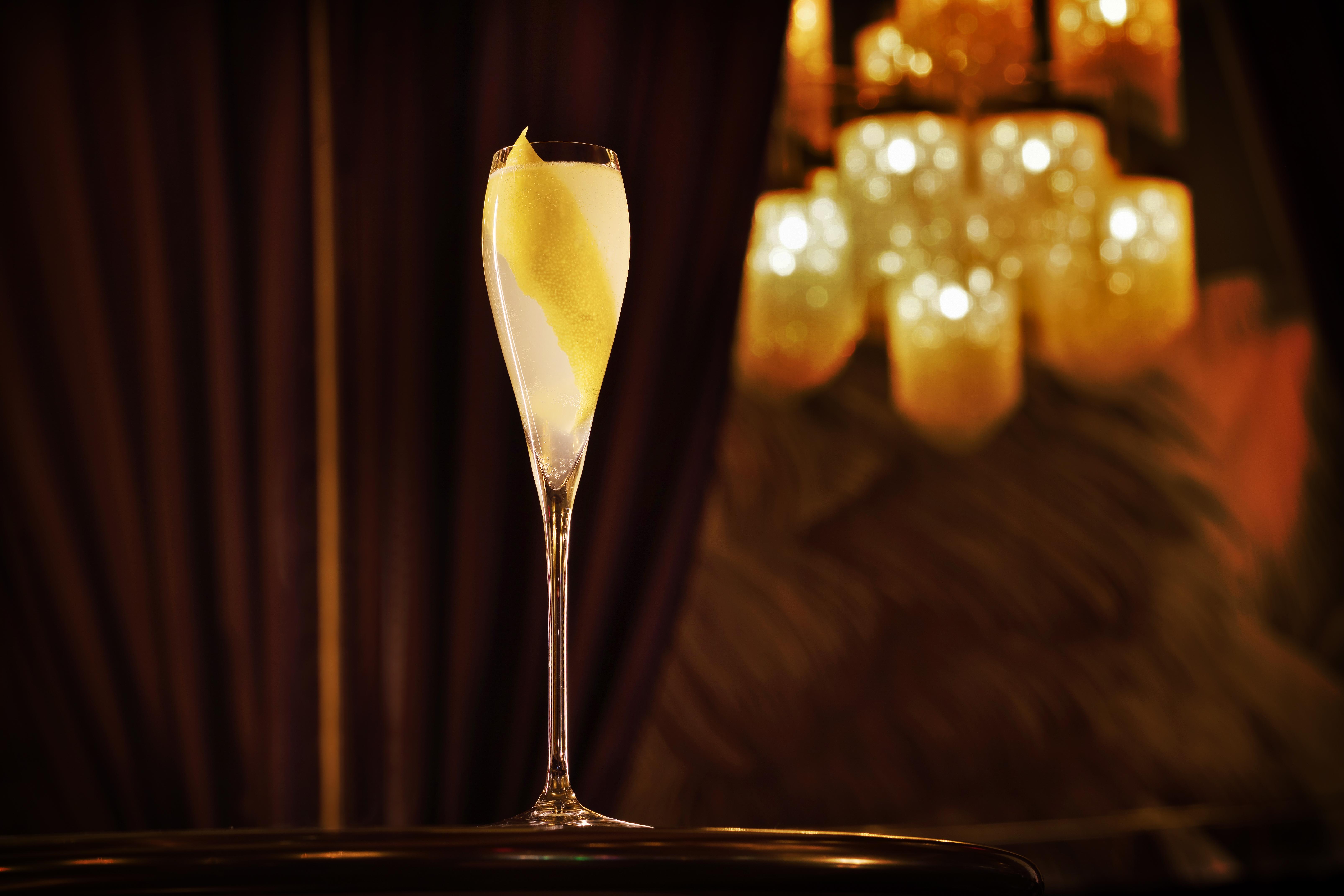 Hotel The Palazzo At The Venetian Las Vegas Exterior foto The photo shows an elegantly arranged champagne flute filled with a light-colored beverage, possibly a cocktail or sparkling wine, featuring a twist of lemon peel as garnish. The glass is set against a backdrop of soft, warm lighting from a chandelie