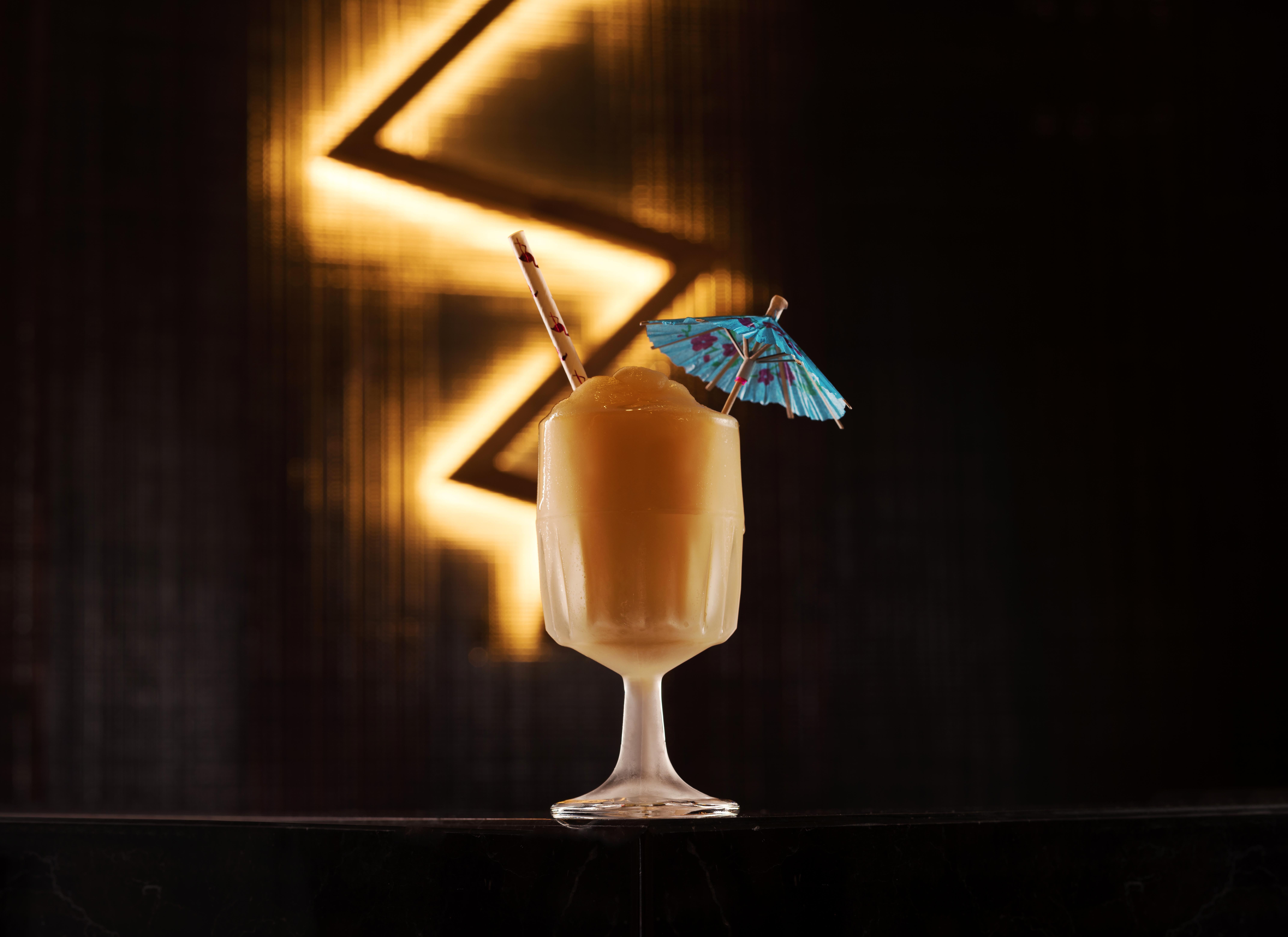 Hotel The Palazzo At The Venetian Las Vegas Exterior foto The photo shows a beautifully presented cocktail in a clear glass. The drink has a creamy, light brown color and is topped with a small blue paper umbrella for decoration. There is also a straw placed in the glass. The background features a dark, ill