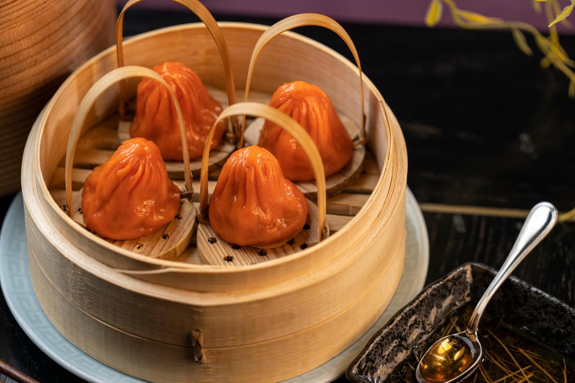 Hotel The Palazzo At The Venetian Las Vegas Exterior foto The photo shows a bamboo steamer containing several dumplings, which appear to be a vibrant orange color. The dumplings are shaped like small pouches with a slightly pleated top, and they are held in place by bamboo strips. The steamer is resting on 