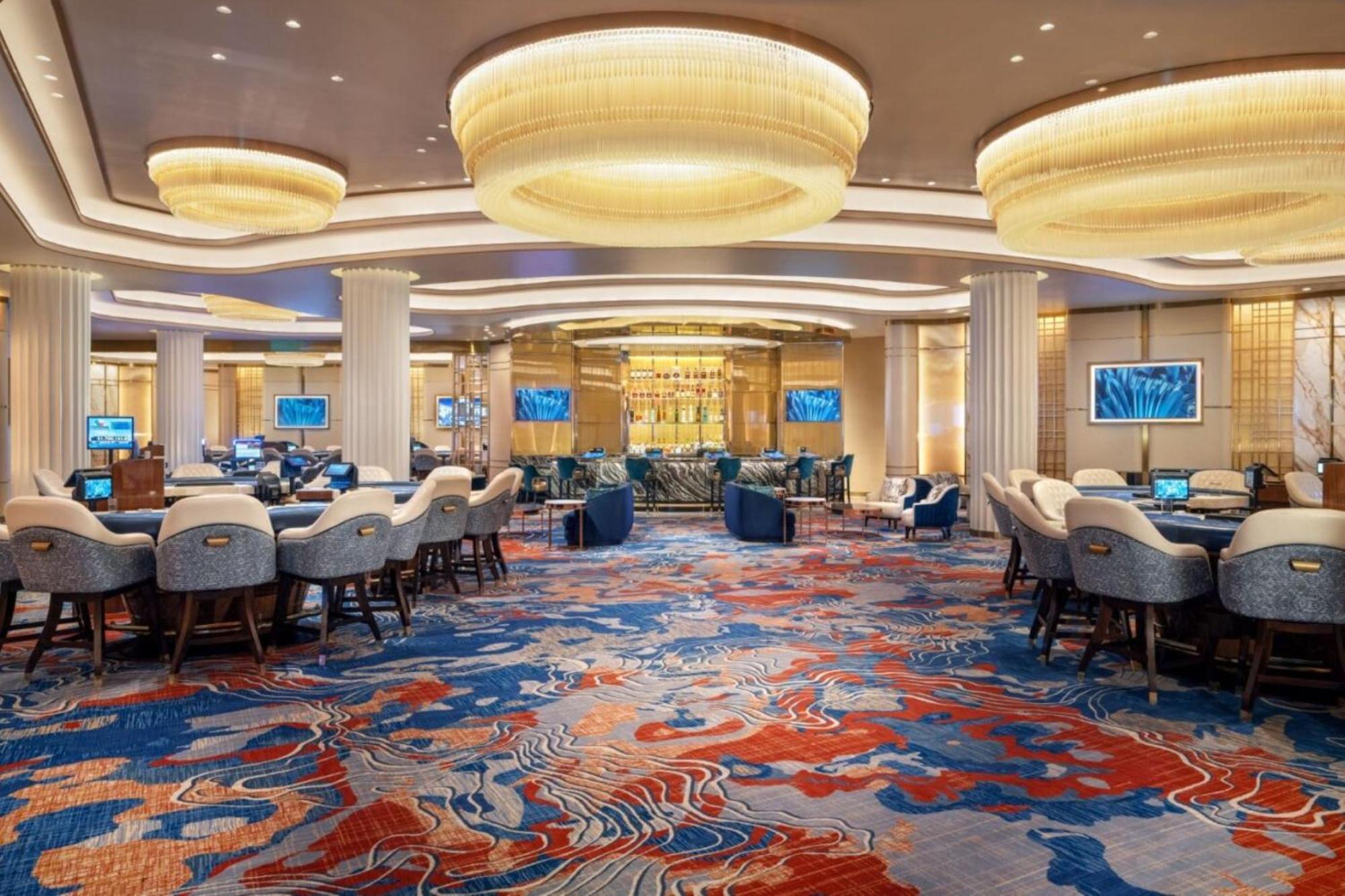 Hotel The Palazzo At The Venetian Las Vegas Exterior foto The photo shows an elegant interior of a casino or gaming area. The space features a variety of seating arrangements, with comfortable chairs and tables for gambling activities. The flooring is adorned with a colorful, abstract carpet design primaril